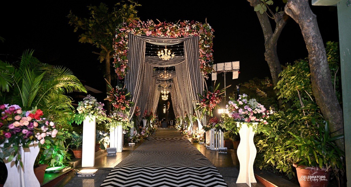 A Celebrators event entrance styled with floral décor and ambient lighting